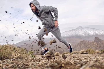 Deurstickers Canarische Eilanden Hispanic man running fast in mountains