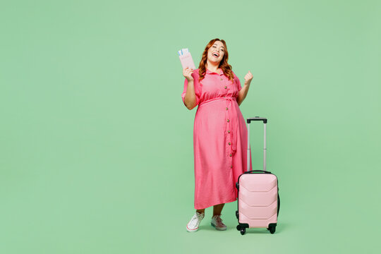 Traveler winner young overweight woman wear casual clothes hold bag passport ticket isolated on plain green background Tourist travel abroad in free time rest getaway Air flight trip journey concept