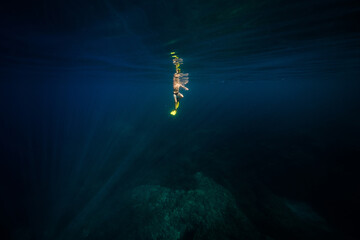 Obraz na płótnie Canvas Anonymous man diving in deep blue ocean