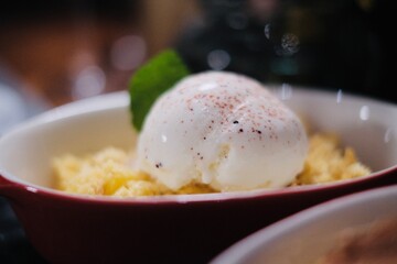 Apple crumble topping vanilla ice cream on a table in a restaurant
