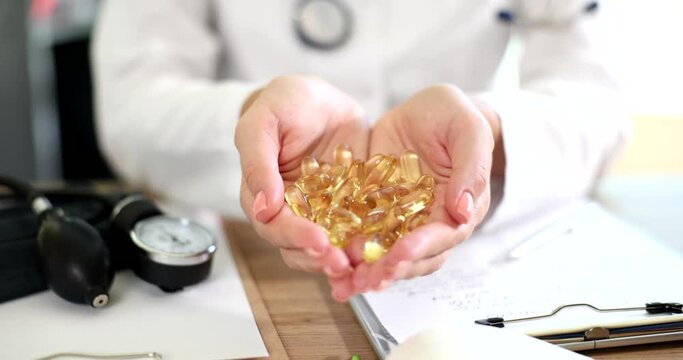 Doctor holding gorse gelatin capsules of omega 3 fatty acids closeup 4k movie slow motion. Treatment with dietary supplements concept