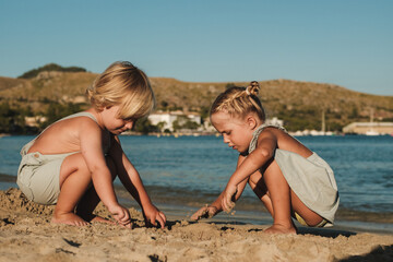 Concentrated kids playing with sand near lake