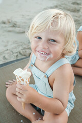 Happy boy eating ice cream on beach