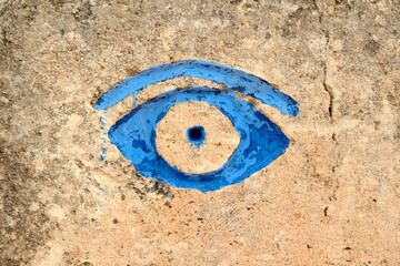 Blue eye painted on stone wall at Lithica