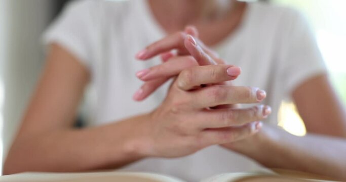 Woman folded her hands and read prayer in front of bible closeup 4k movie slow motion. Faith in God concept