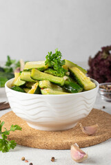 Pickled cucumbers slices with mustard, garlic and paprika in white bowl, Closeup