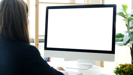 Woman using desktop computer with blank screen for mock up template background