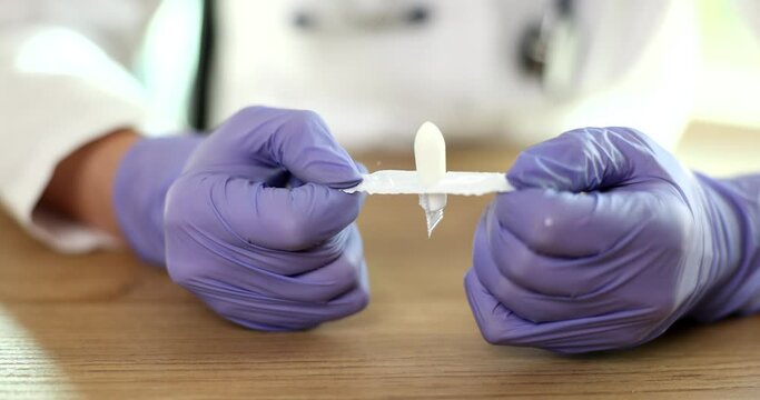 Doctor gynecologist in gloves opening antiinflammatory suppository closeup 4k movie slow motion. Hemorrhoid treatment concept