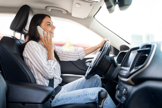 Happy Millennial Woman Driver Talking On Phone While Driving Auto