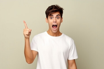 Fototapeta premium Young surprised man in white t-shirt looking at camera with an open mouth, pointing right. Isolated background.Generated AI 