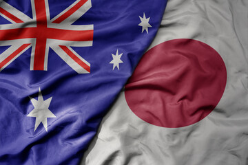 big waving realistic national colorful flag of australia and national flag of japan .