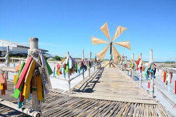 Windmills and bamboo bridges with a bright blue sky in the salt fields