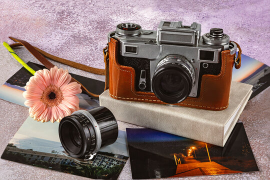 Old camera, old photo lens, color photos, photo album and gerbera flower on the table. World Photography Day, August 19, concept