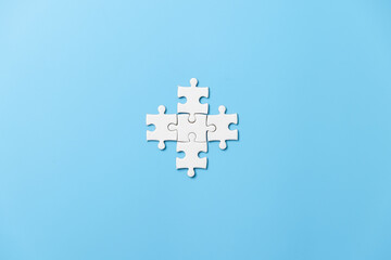 Many white jigsaw puzzle on blue background - idea solution concept.