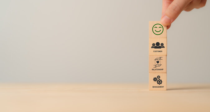 CRM, Customer relationship management concept. Customer satisfaction, retention strategies. CRM or customer loyalty program banner. Wooden cube blocks with CRM symbols on minimal background.