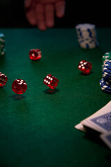 there are red dice and poker chips on the green cloth