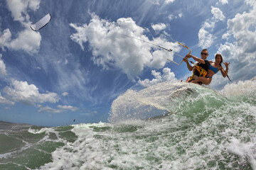 Lovely couple up on one kite board. Woman Riding On Kite surfer's Back and kiting on a sea © Oleg