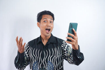 Photo of positive excited man screaming and looking cellphone isolated over white background