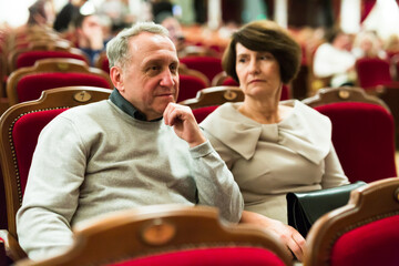 Mature man and woman in theater watching a performance