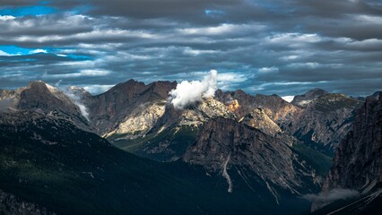 Fototapeta na wymiar Landscape featuring a majestic mountain range set against a backdrop of clouds
