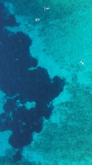 Fototapeta na wymiar Aerial view of boats in crystal clear blue ocean waters of Corfu Island in Greece.