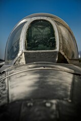 Close-up of an exterior of an old fighter jet cockpit against a clear sky