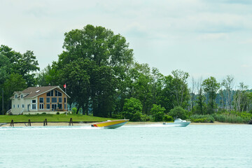 yellow speedboat speeding past cottage on stag island st clair river in ontario - 629215169