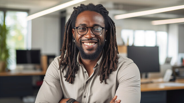 Smiling black man with dreadlocks on the background of the office. Office worker