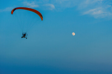 paragliding on blue sky with full moon