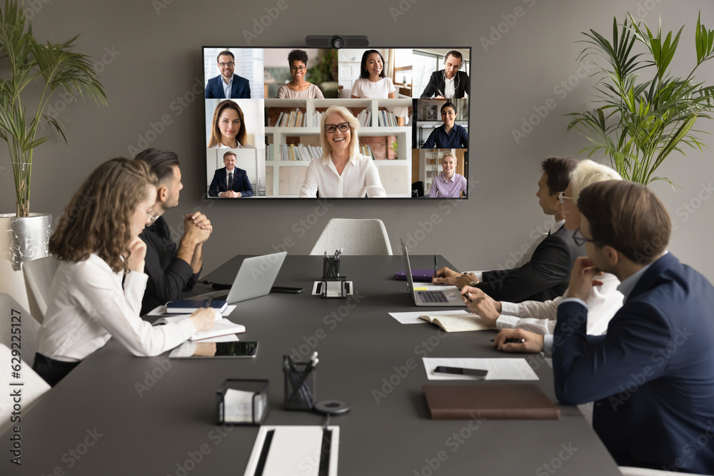 Wall mural cheerful mature business mentor woman training diverse office staff on video conference chat, speaki