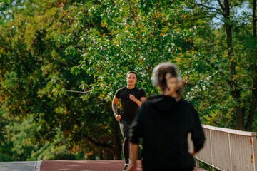 Obraz premium Two friends running on a sports track in the park