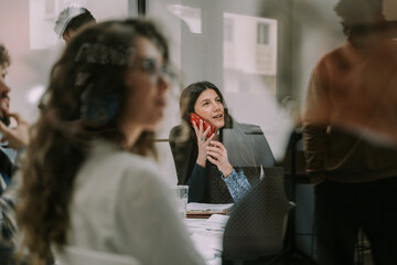 A gorgeous brunette businesswoman talking to her colleague while having a phone call