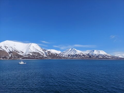 Serene Winter Landscape: Majestic Mountains, Pristine Snow, and Tranquil Sea a view from svalbard and jan mayen norway