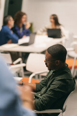 African american male working alone with colleagues in the background