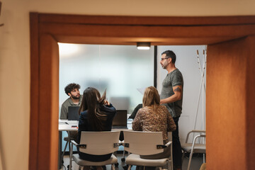 Angry middle-aged project manager looking at his coworkers not paying attention to him