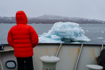 Man watching iceberg from a boat