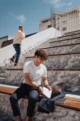 Freelancer worker putting documents in the lap top, finishing working hours, about to go home