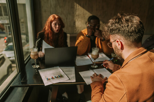 Business people working at the coffee bar. Man writing in notebook