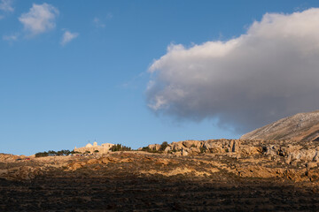 Anafi island -spectacular mountainous landscape,in background there is Monastery of Zoodohos Pigi. Cyclades islands, Greece
