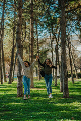 Fototapeta premium Two happy, smiley, gorgeous girls, dancing while walking in the park