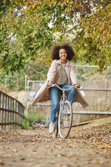 Smiling young woman enjoying bicycle ride in park