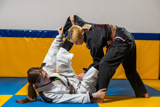 Young girls practice Brazilian jiu jitsu in the gym