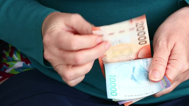 Chilean Pesos, Woman Counting Money, Cash Payments in Chile, Business and Finance, Home Budget, close up