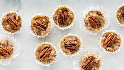 A top down close up view of several salted caramel pecan tartlets in a row.