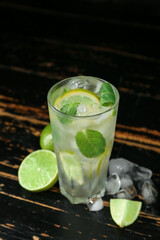 Glass of tasty mojito on dark wooden background