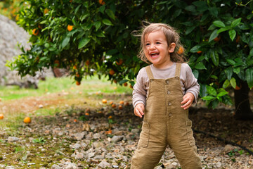 Happy girl on land against orange tree