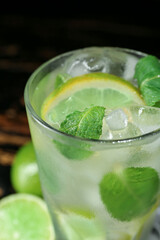 Glass of tasty mojito on table, closeup