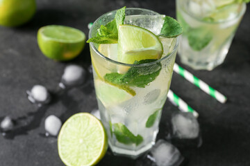 Glass of tasty mojito on dark background