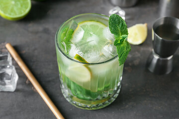 Glass of fresh mojito with ingredients on grunge background