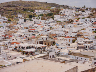 Lindos town in Greece aerial view in cloud summer day, white houses in Rhodes island , cityscape viewpoint traditional greek architecture, famous landmark and touristic destination concept